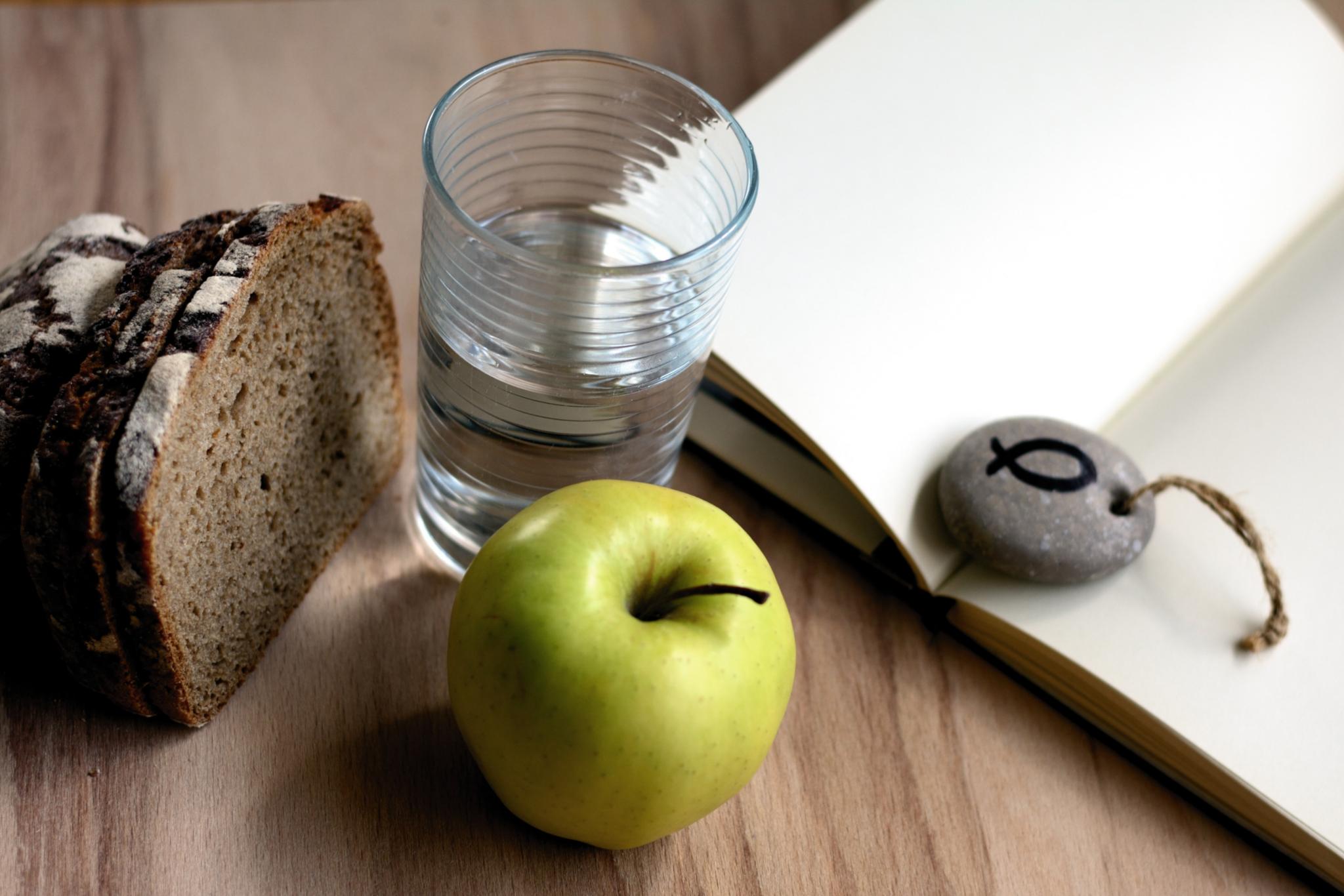 Brot, Apfel, Glas Wasser und ein Stein